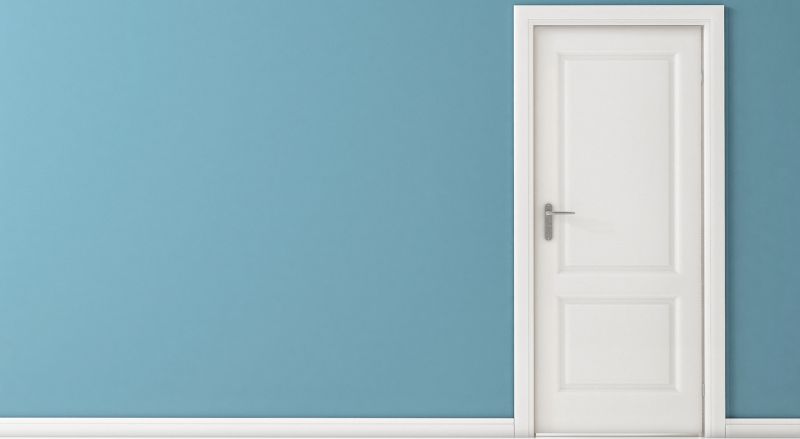 porte blanche avec un joli encadrement sur un mur bleu