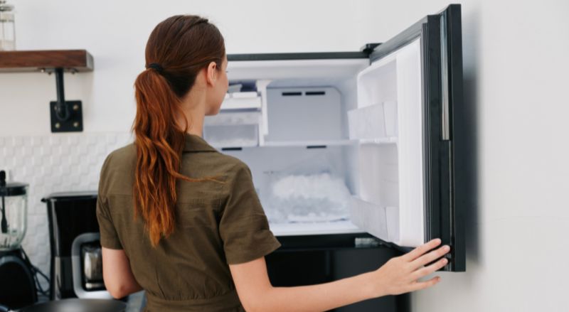 femme qui ouvre un congélateur