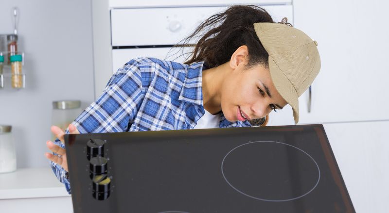 Femme qui installe une plaque de cuisson dans une cusine