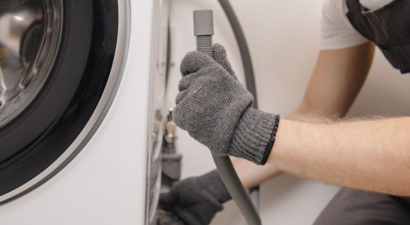 professionnel montrant l extremite du tuyau d evacuation d une machine a laver