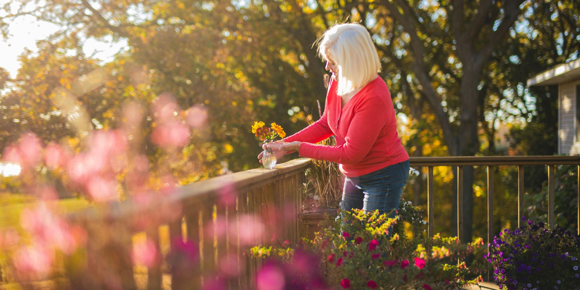 Femme en train de garnir son balcon de fleurs.