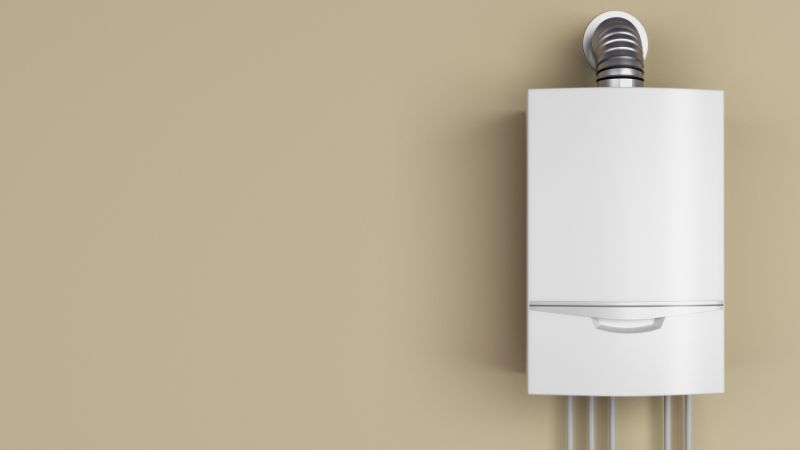 chaudiere gaz murale avec ventouse sur un mur uni beige