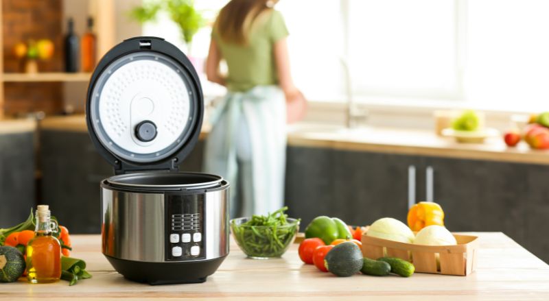 robot cuiseur Cookeo pose sur un plan de travail de cuisine avec divers aliments