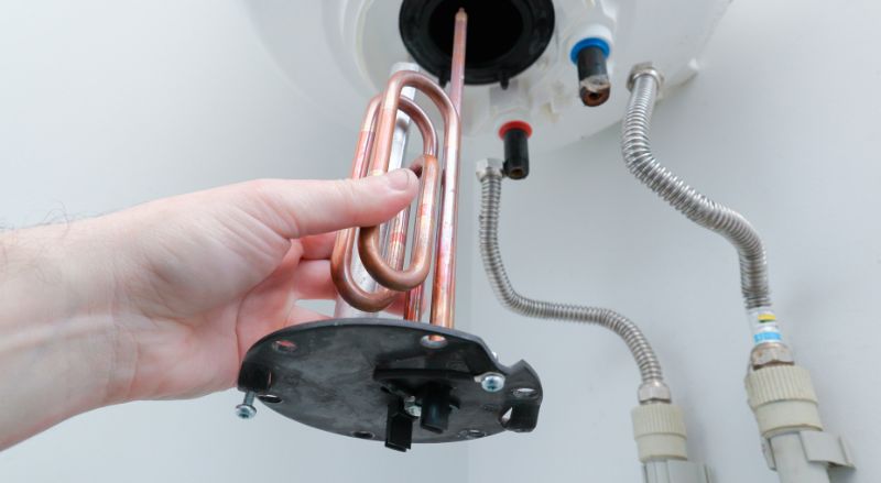 main d homme en gros plan changeant une resistance de chauffe eau lors d une maintenance