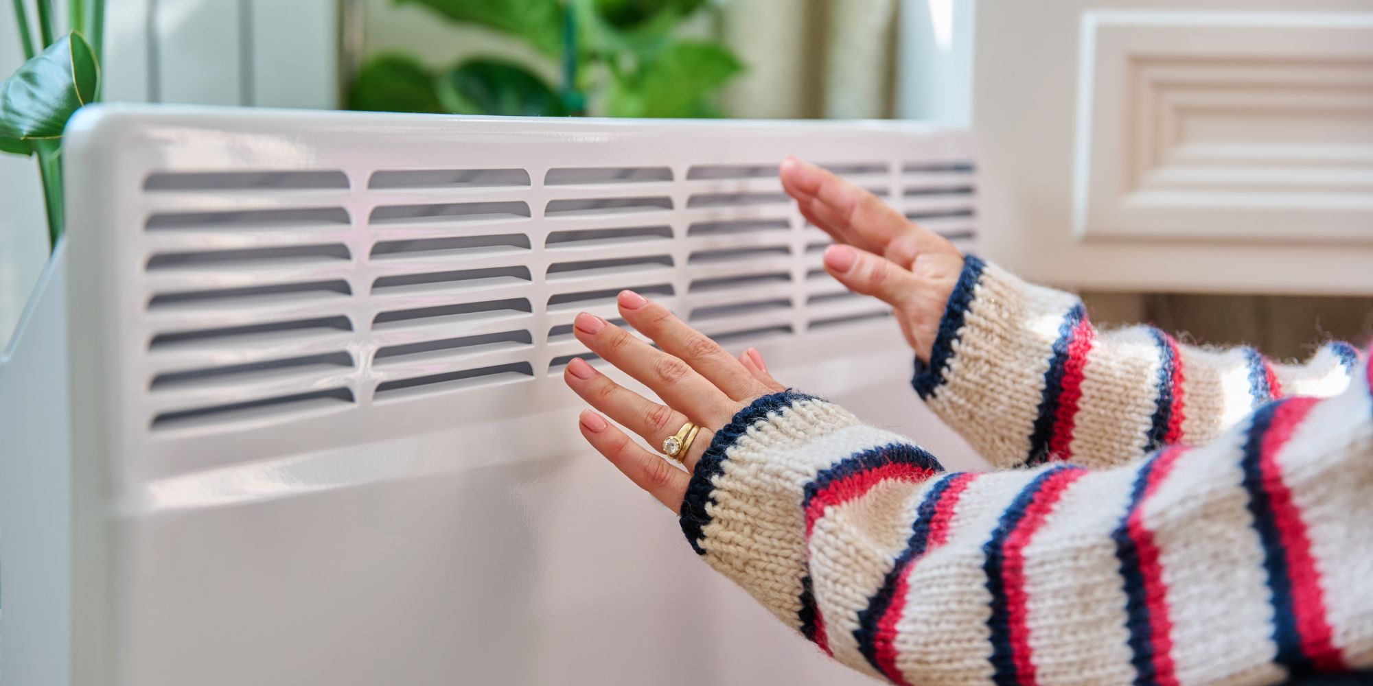 des mains devant un radiateur électrique