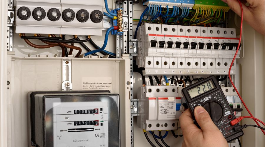 électricien faisant des tests au multimètre sur un tableau électrique