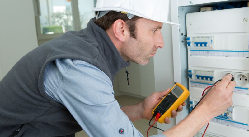 electricien testant les circuits via le panneau d un logement