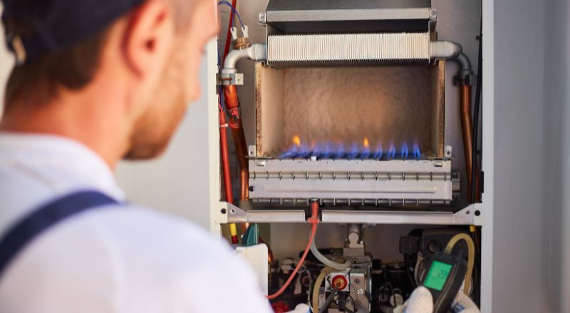 un chauffagiste ajuste la combustion du gaz dans une chaudiere