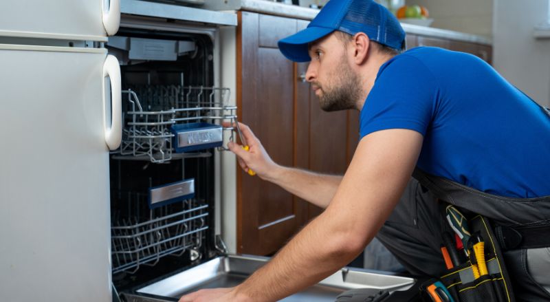 reparateur intervenant sur un lave vaisselle dans une cuisine