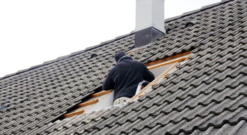 homme couvrant un toit avec des tuiles
