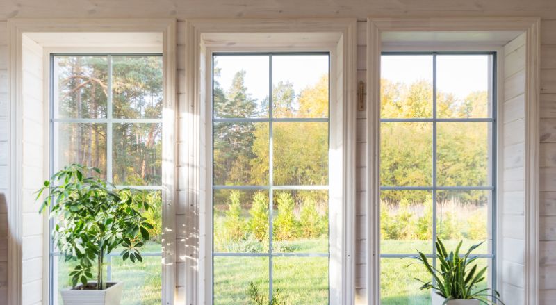 interieur lumineux avec trois grandes fenetres avec contour en bois clair moulure