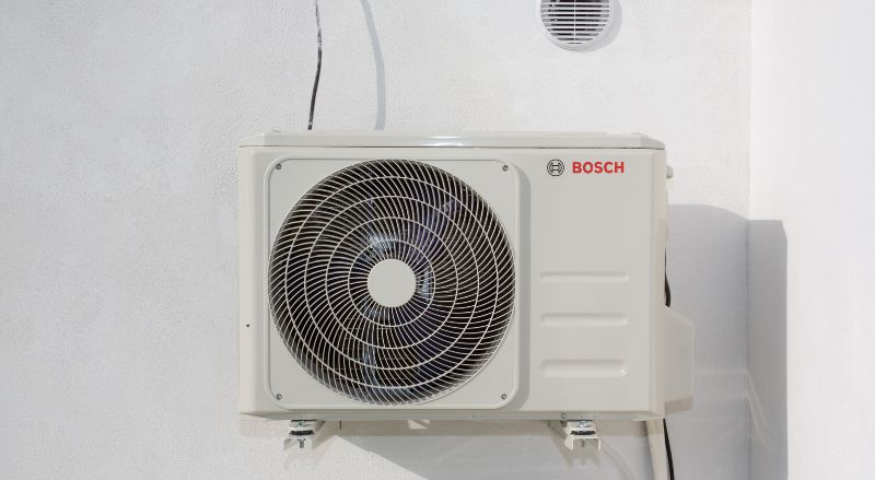 pompe a chaleur de marque bosch fixee en suspension contre un mur