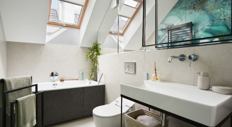 petite salle de bain sous pente avec baignoire la ou le plafond est bas et mur de miroirs pour demultiplier la sensation de volume