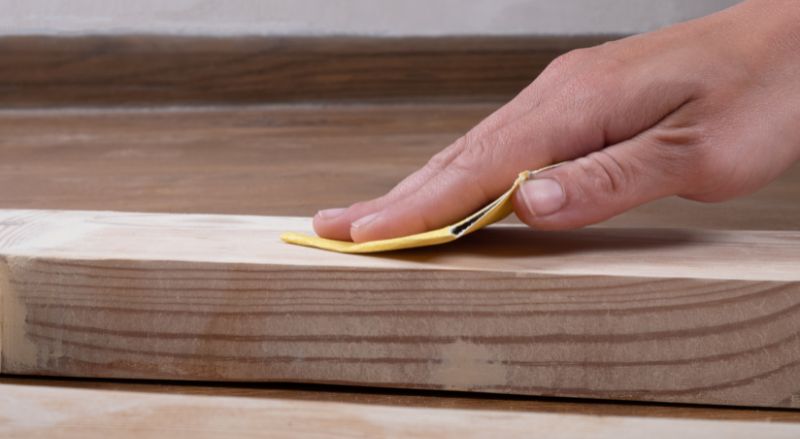 ponçage d'une porte avec du papier de verre