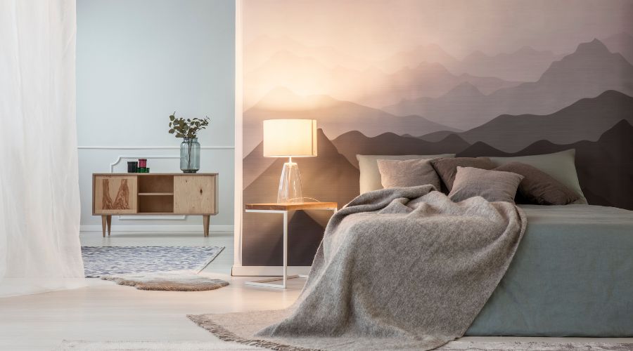 chambre moderne aux tons gris taupe violine avec un lit une lampe de chevet panoramique et un papier peint panoramique en guise de tete de lit