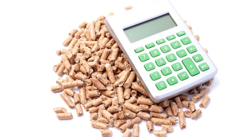 une calculette posee sur une poignee de granules pour symboliser le prix de ce combustible