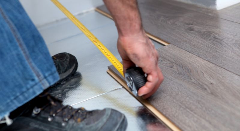rtisan qualifie en train de poser du parquet flottant