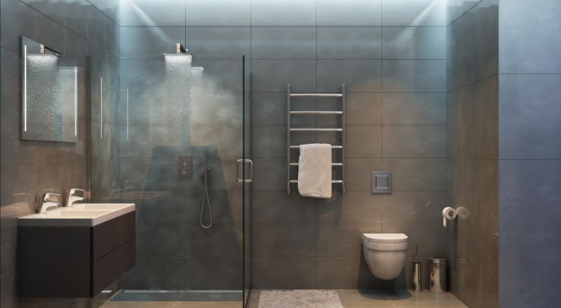salle de bain moderne entierement carrelee en gris ambre avec large douche a l italienne meuble vasque noir seche serviette en inox wc suspendu et eclairage tamise